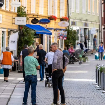 Folkrik kullerstensgata i litetcentrum med färglada hus