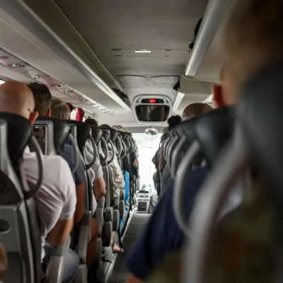 Bussresenärer i sina stolar på en buss, bakifrån.