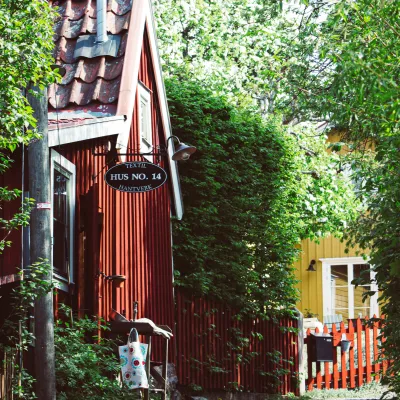 Grön lummig gata med gamla hus i rött och gult